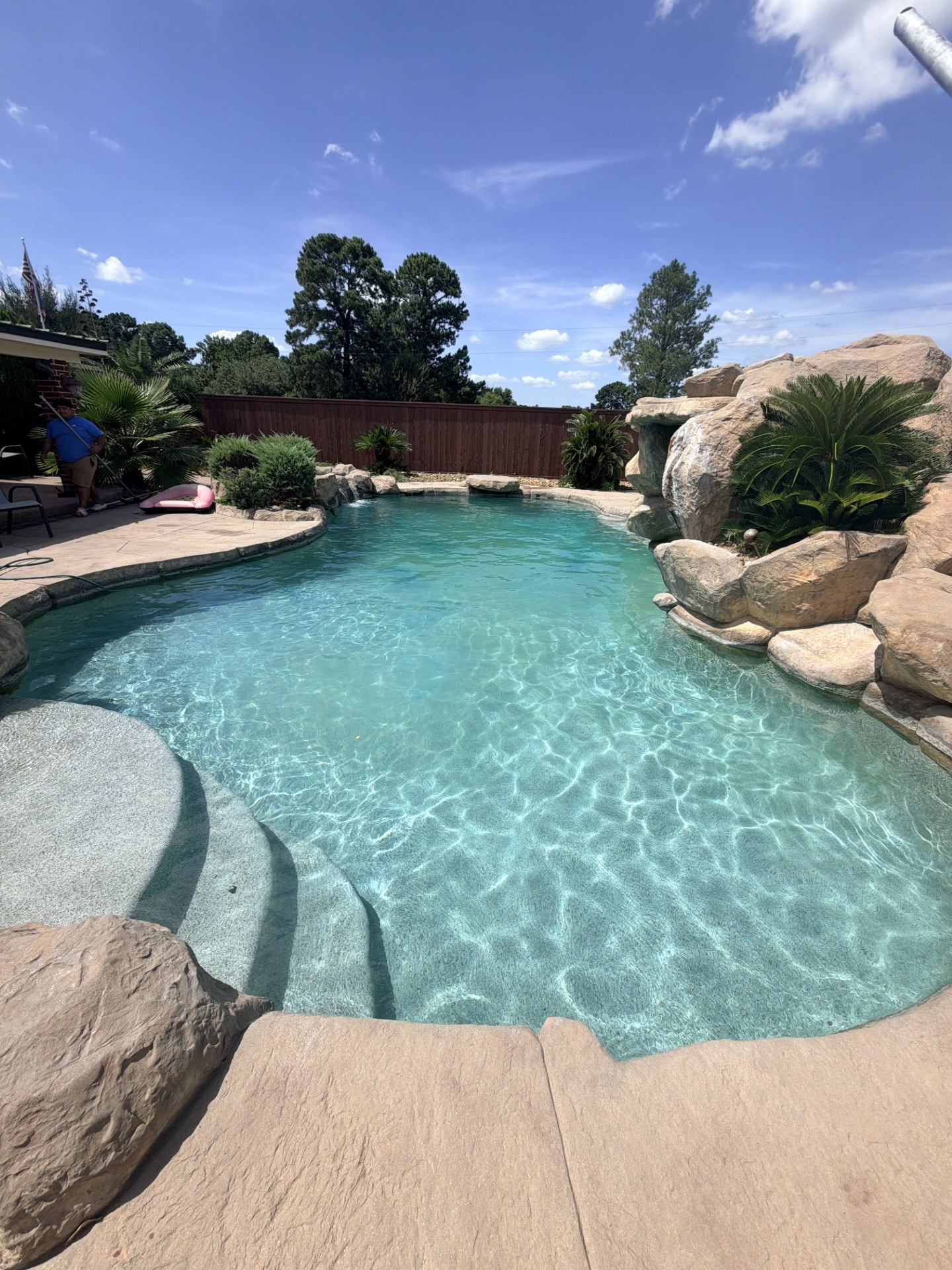 Freeform pool with rock waterfall and landscaped surroundings