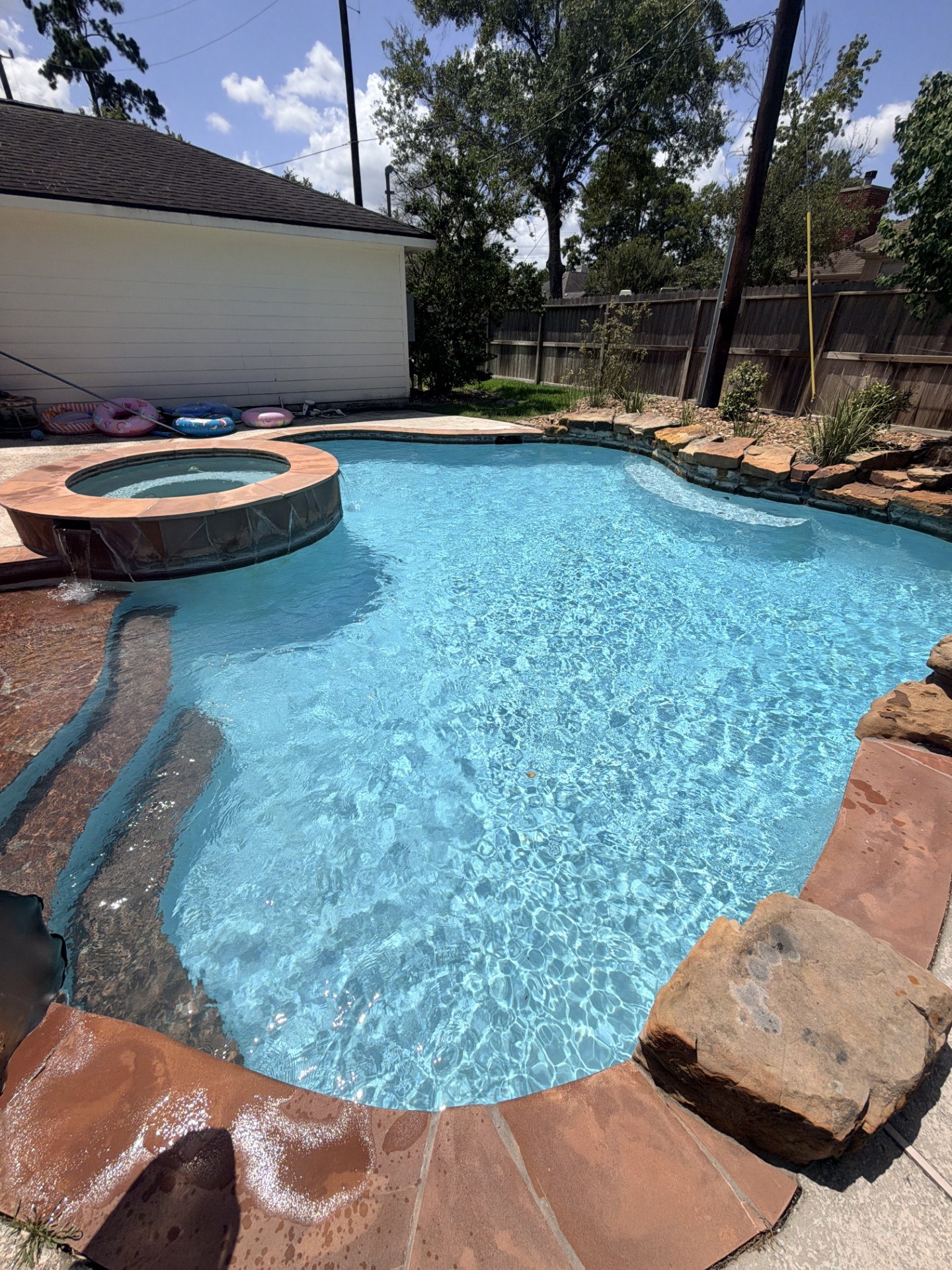 Curved swimming pool with raised circular spa